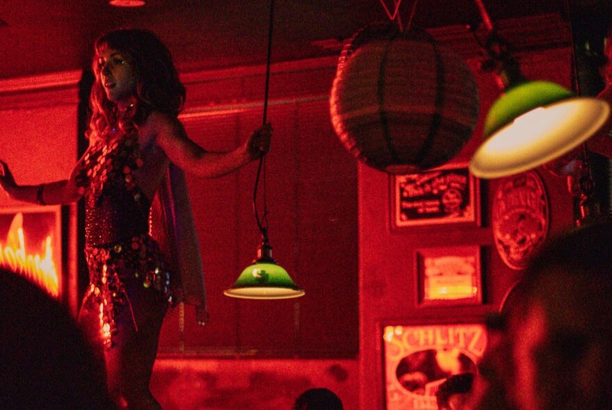 Drag performer hosting bingo in the dimly lit Heartbreaker Bar.