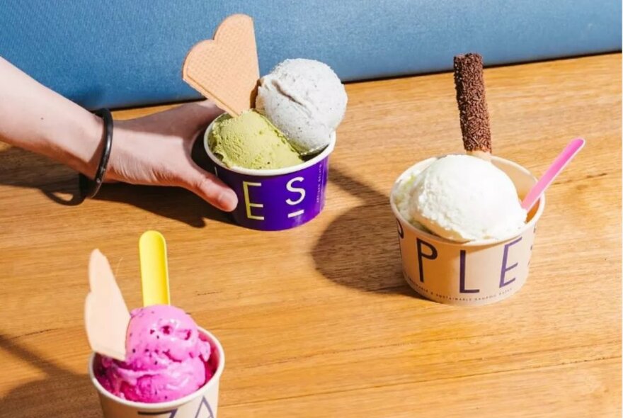 A trio of colourful gelato cups with heart shaped wafers.