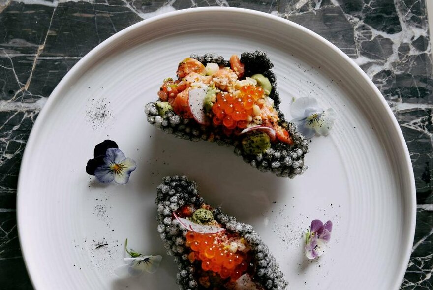 Small morsels on white plate, seen from above.