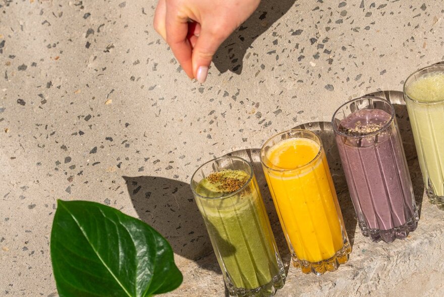 An angled photograph of four different coloured juices and smoothies. 