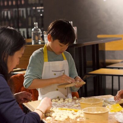 Children making gnocchi in a workshop.
