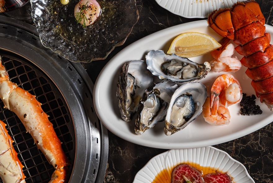 Bowls of seafood including oysters and crab legs.