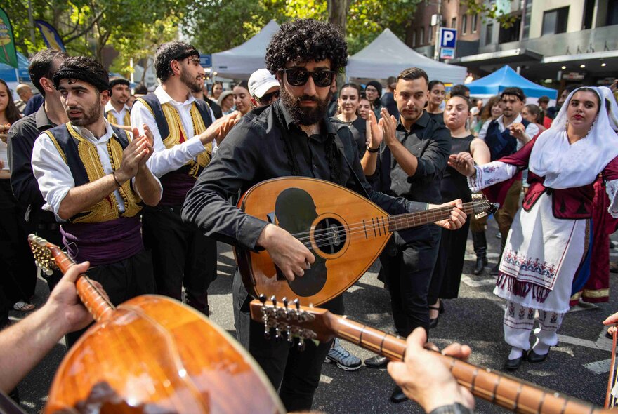 Bouzouki players performing live at a street festival.