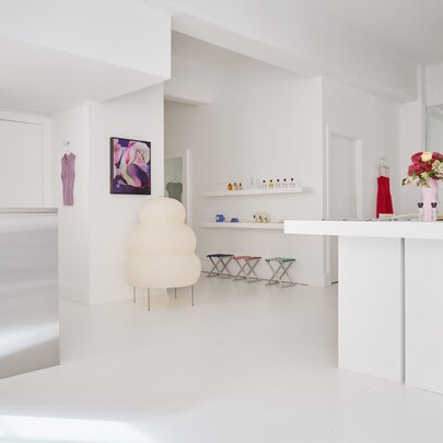 A sparse white shop interior with a centre counter, white floors and walls.