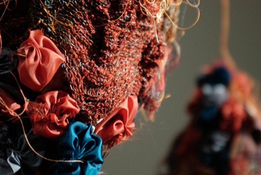 A textile artwork made from wool and silk rosettes.