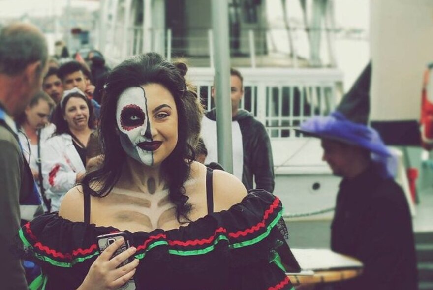 A person dressed in a spooky outfit and makeup on a ship.