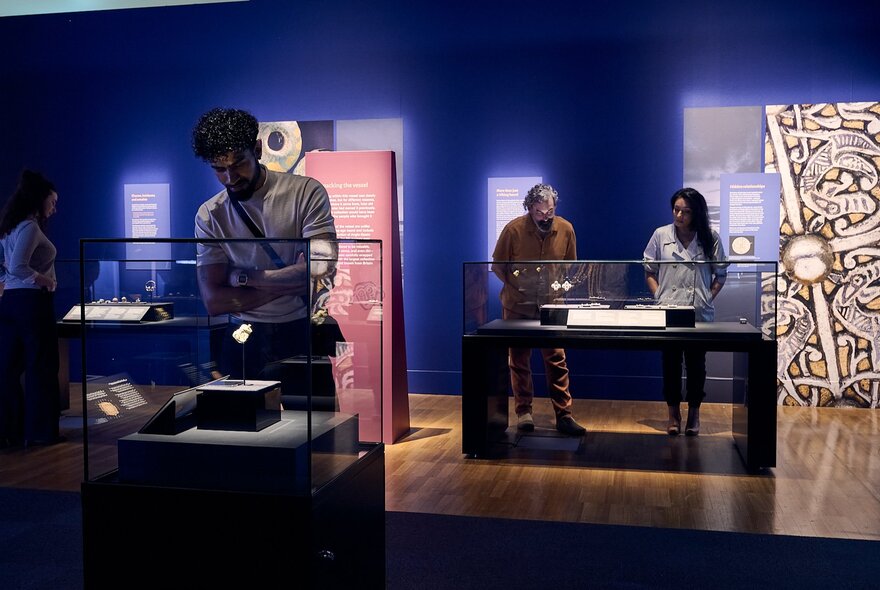 People looking at display cases from the Treasures of the Viking Age: The Galloway Hoard exhibition at Melbourne Museum.