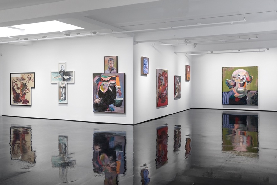 A selection of Ben Quilty's paintings from his exhibition, Trinkets, displayed on a white gallery wall and reflected on the shiny black floor.