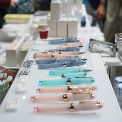 A selection of pearlescent pens presented on a white surface.