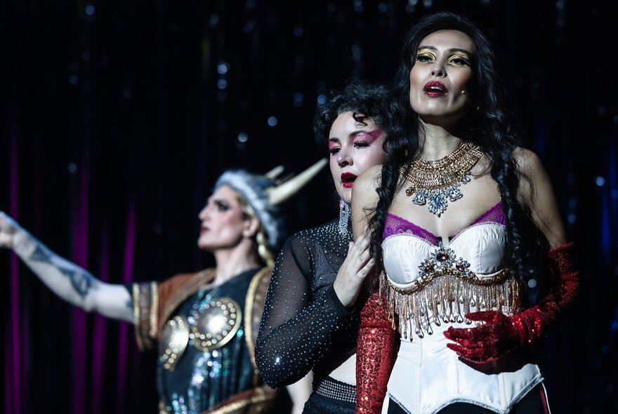 Three opera singers performing in costumes.