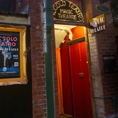 A red doorway with a sign for Piccolo Teatro. 