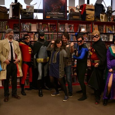 People dressed up as comic book characters in a bookshop setting. 