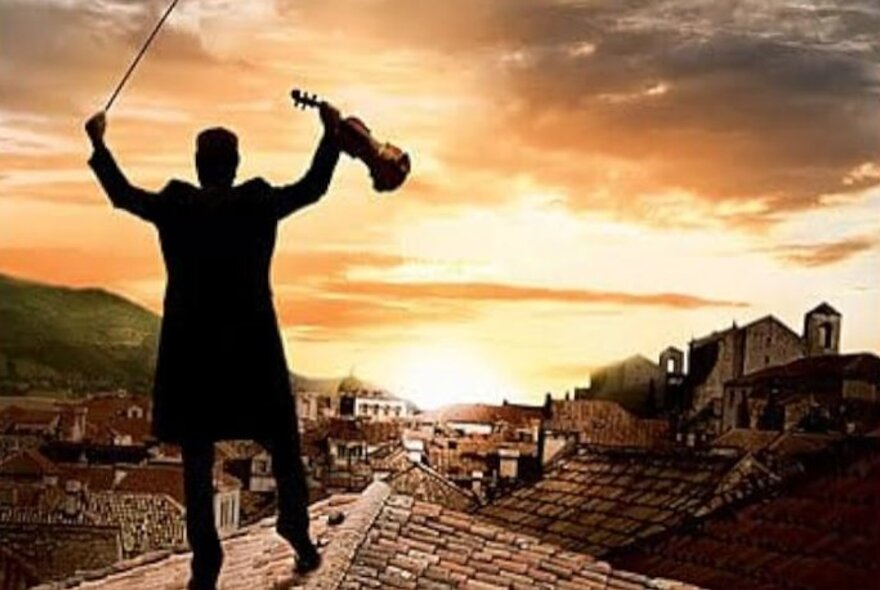 Poster for the 1971 musical film Fiddler on the Roof features the main character silhouetted on a roof against a sunset while holding a violin.