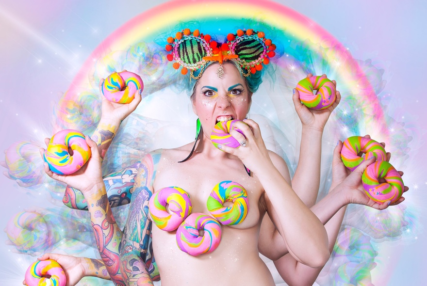 An image of a naked woman with multiple arms and hands all holding pastel-coloured doughnuts with a rainbow over her head. 