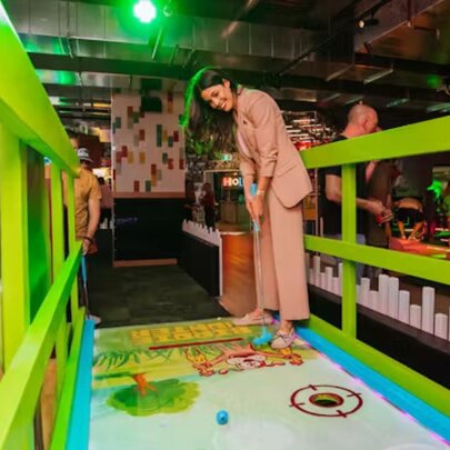 Person playing minigolf in an indoor venue.