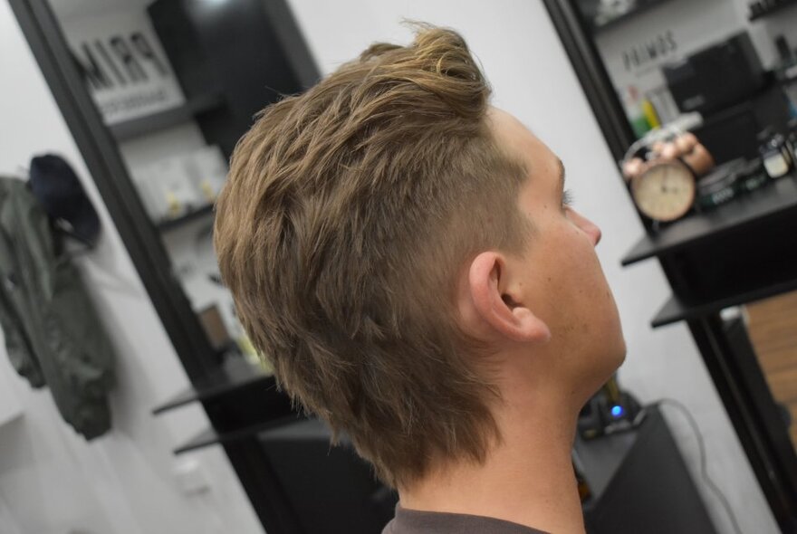 A view from behind of a fresh haircut in a barber shop. 