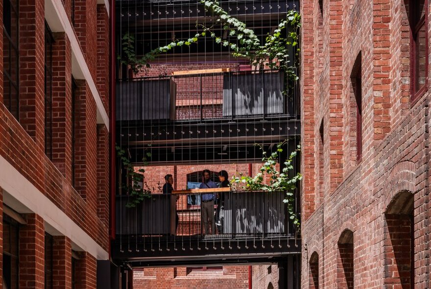 Redeveloped warehouse industrial building with tiered floors, red brick walls and decorative plants.