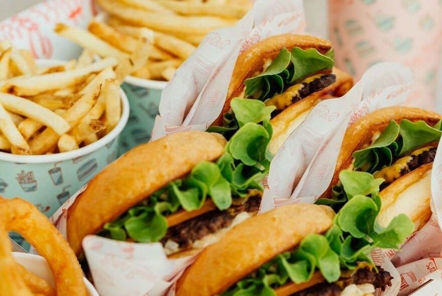 Row of burgers and buckets of chips.