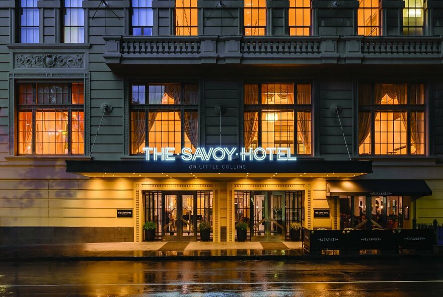 Savoy Hotel exterior with signage, period multipaned windows and grand entry.