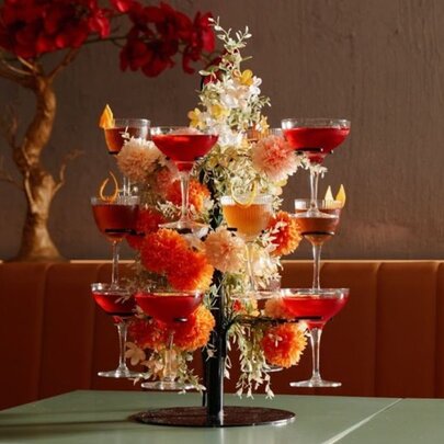 A tabletop tree statue holding different pink cocktails.