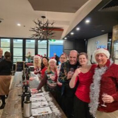 A group of people wearing festive Christmas clothes in a restaurant.