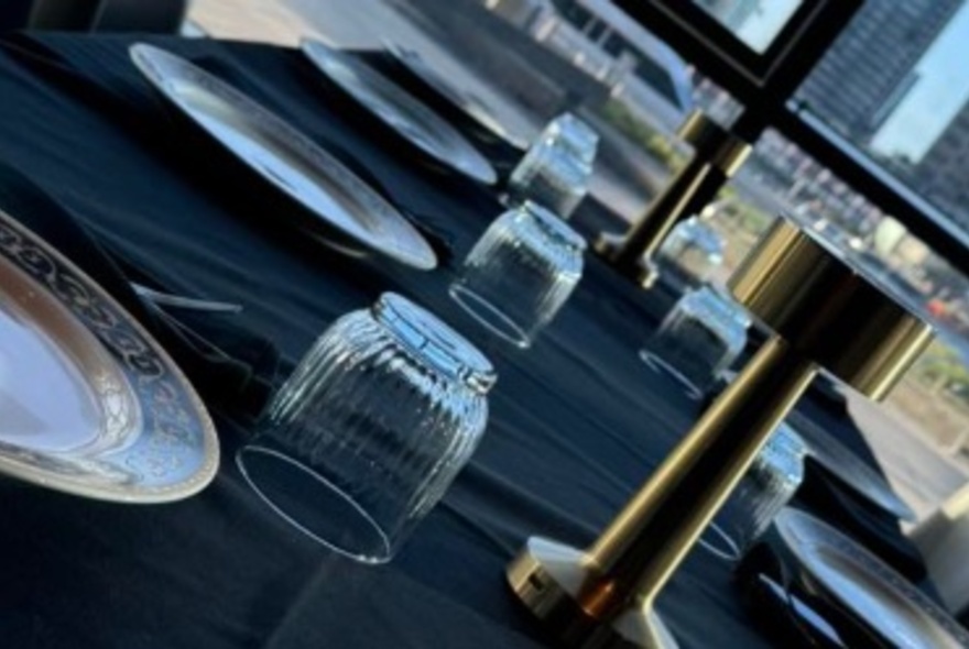 A diagonal view of a set table with glassware and plates.