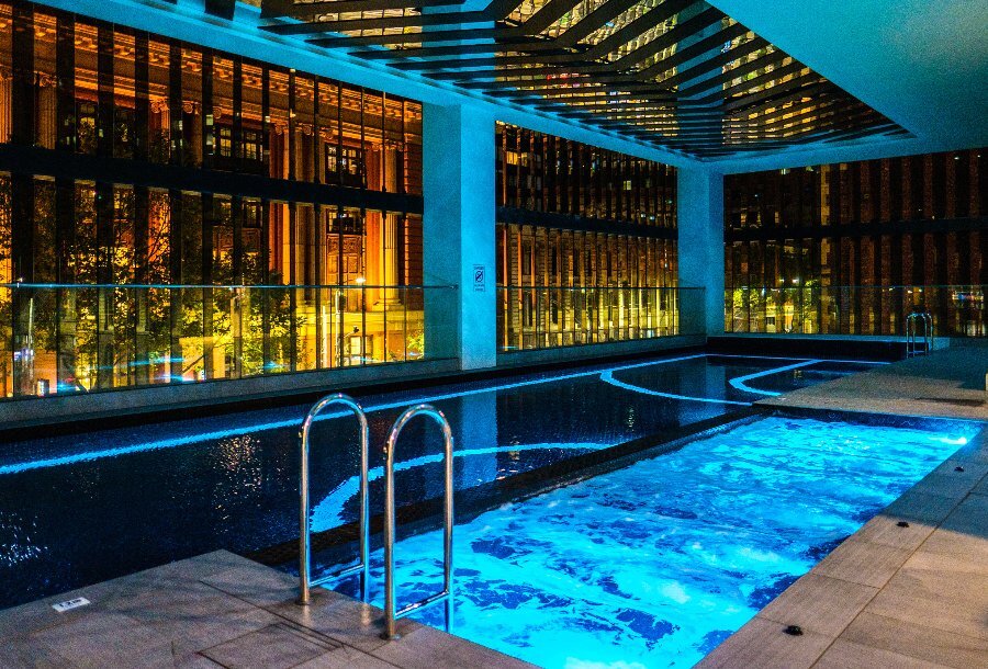 A hotel pool lit up in blue