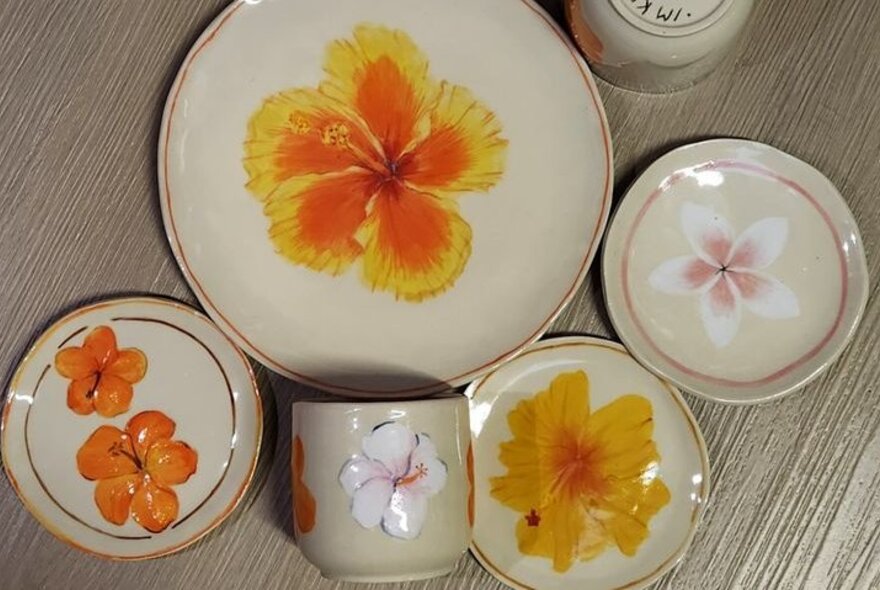 A selection of crockery all with hibiscus and frangipane designs.