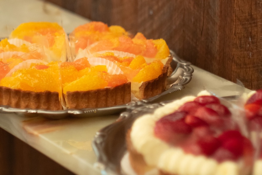 French fruit flans displayed on silver platters.