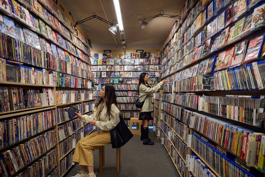 Two women browsing in a DVD store.