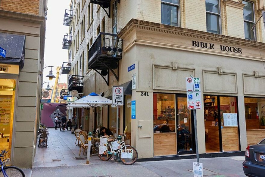 Street view of a small cafe on a corner with a laneway.