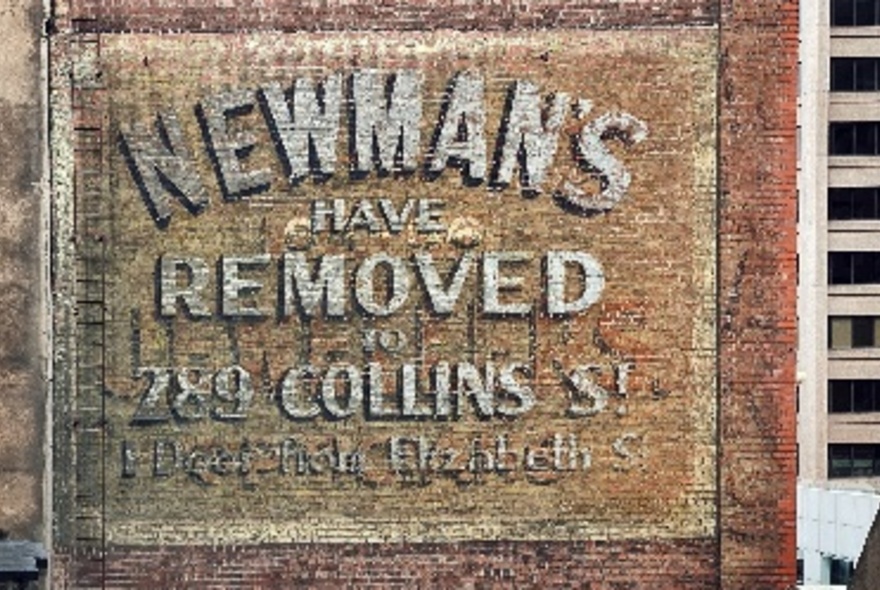 An old sign announcing that Newman's have removed to Collins Street. 