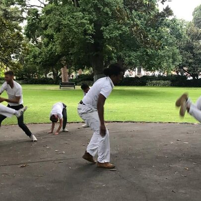 Men wearing white dancing Capoeira in Flagstaff Gardens.