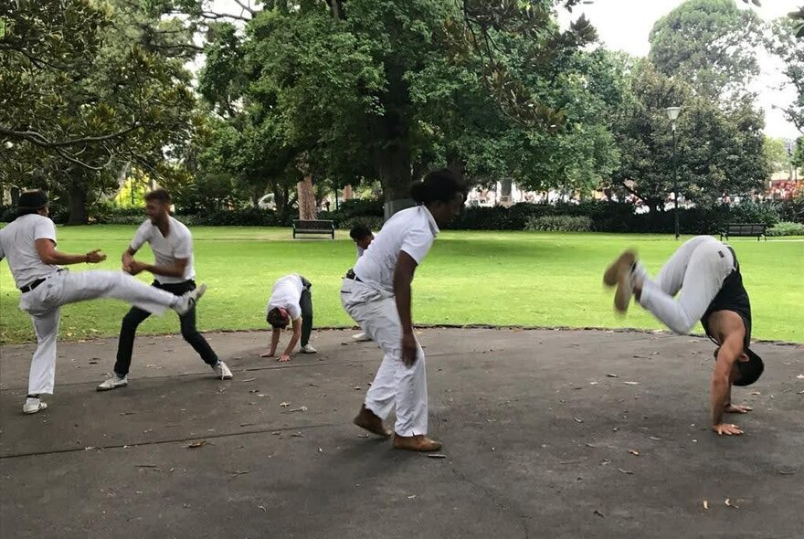 Men wearing white dancing Capoeira in Flagstaff Gardens.