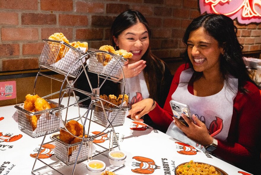 Diners wearing bibs with a fried fish served in novelty trays shaped like a big wheel.