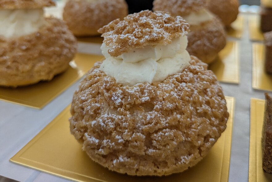 French pastries resting on individual gold squares.