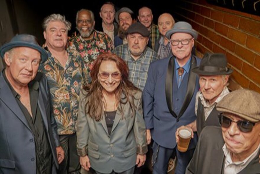 Large group of musicians, some wearing hats.