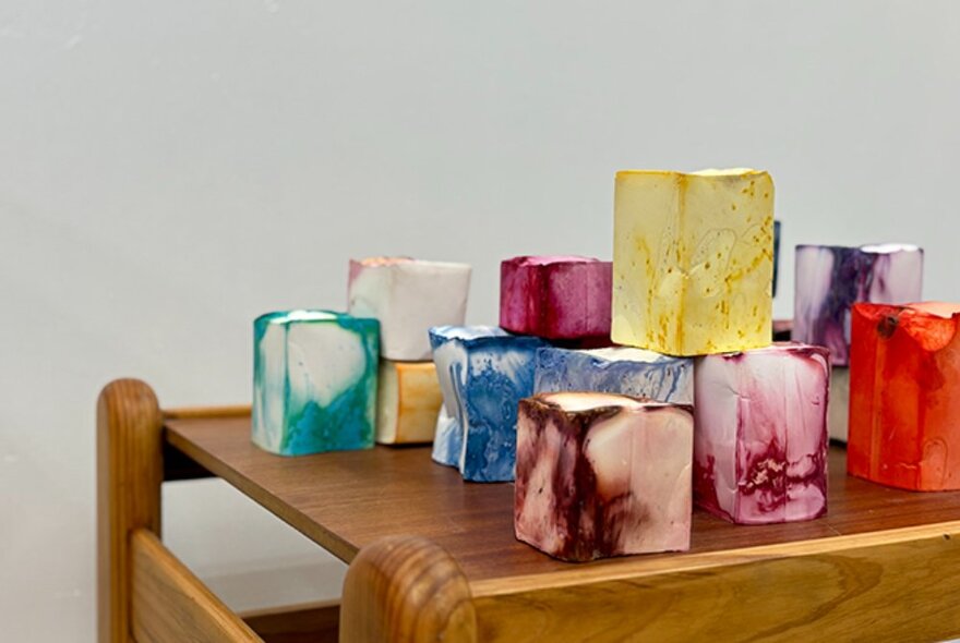 Coloured blocks stacked on a wooden side table, each with various water swirl patterns on them.