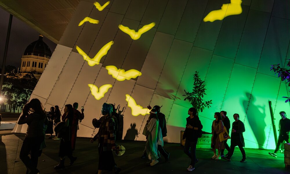 Bat projections on the exterior of the museum at night.