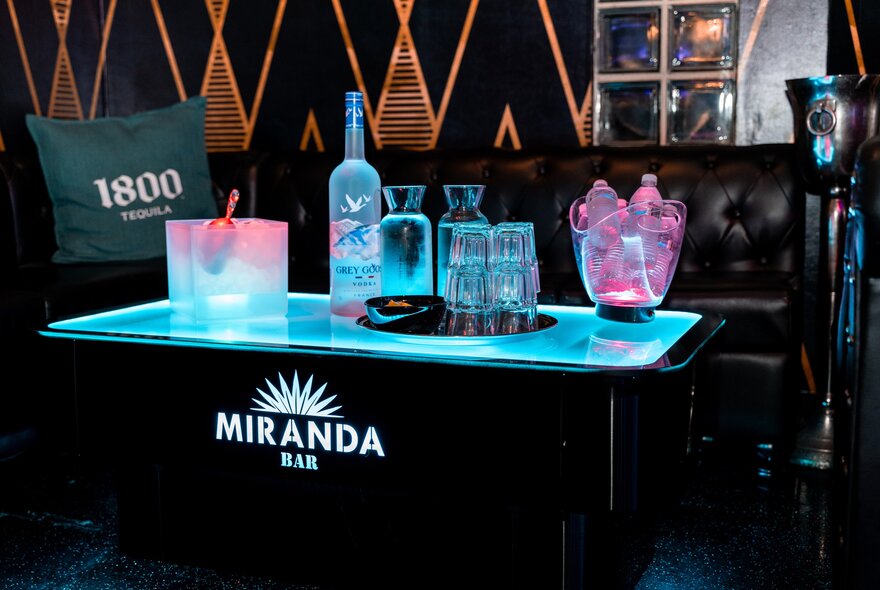 A couch and table set up with drinks at Miranda Bar.