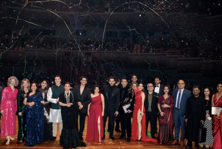 A row of people in suits and elaborate gowns lined up at the Indian Film Festival Awards night.