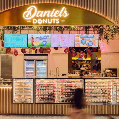 The shopfront of Daniel's Donuts with glass display cabinets filled with donuts.