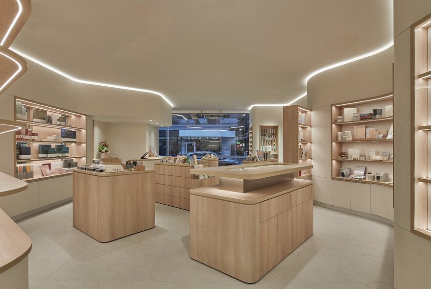 Store interior with beige walls and wooden display benches and shelves, displaying stationery goods.