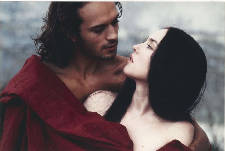A still from the film La Reine Margot, of a man and a woman looking at each other in a close embrace.