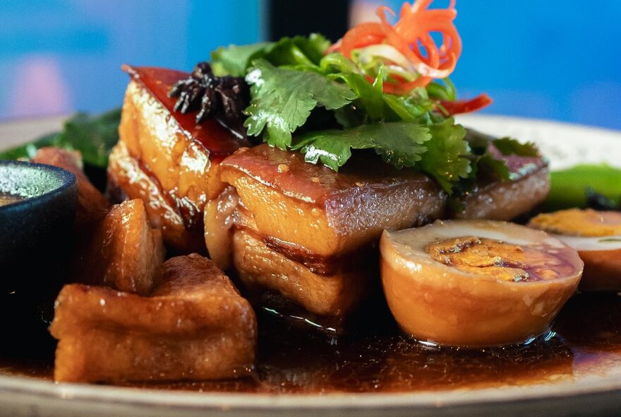 A succulent-looking pork belly dish with son-in-law eggs and a rich sauce.