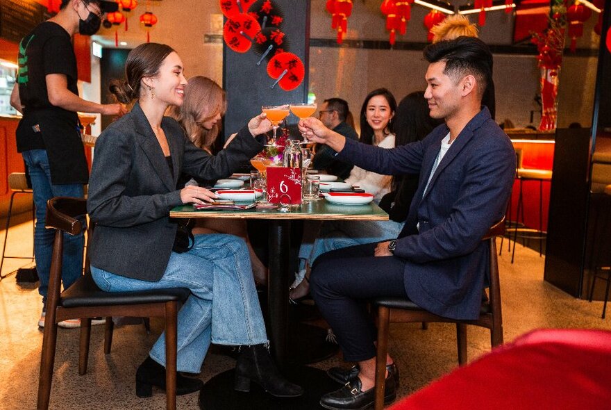 Patrons seated at tables inside a restaurant eating and drinking.