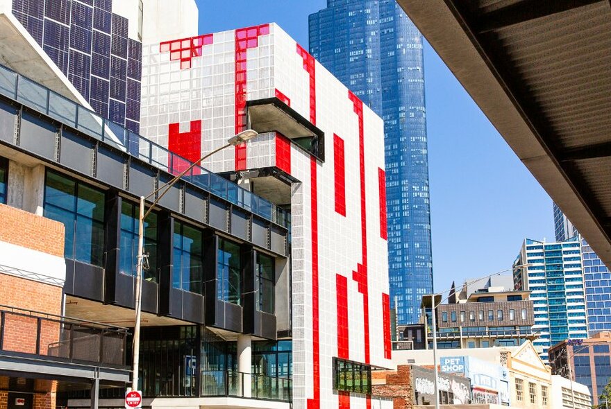 City building showing large scale public artwork spelling out the word MORE wrapped around the facade.