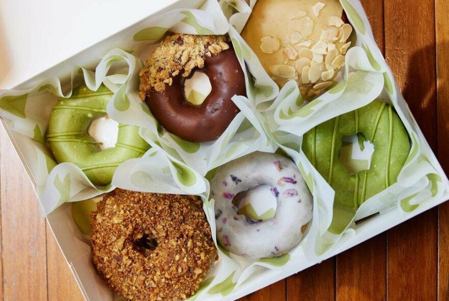 Different flavoured donuts in a white box.