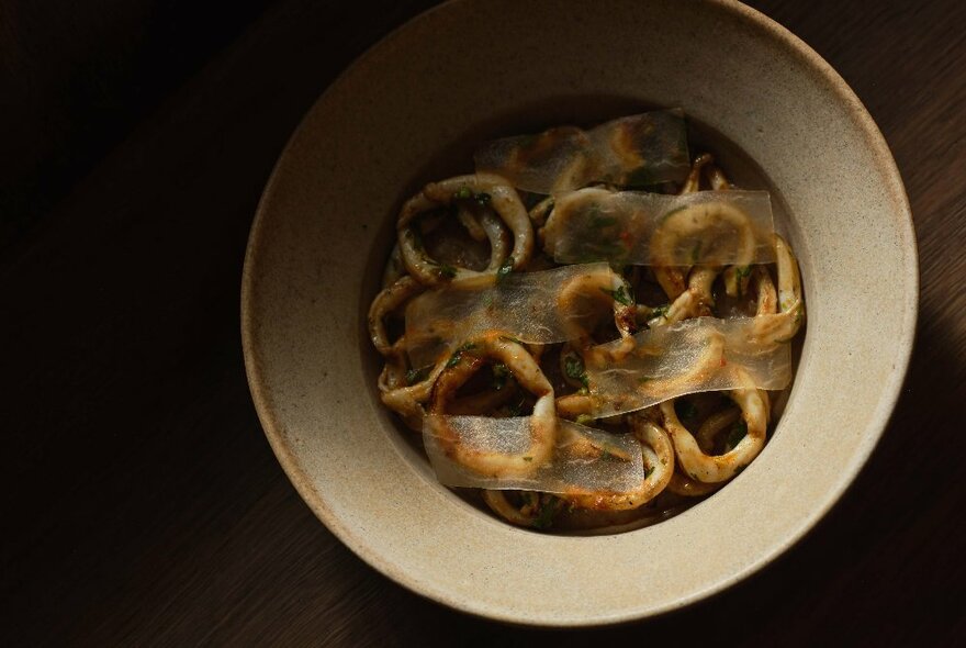 An earthenware bowl of food on a table.