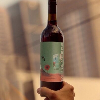 Hand holding up a wine bottle.
